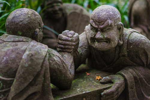 Sculptuur van worstelende kale monniken